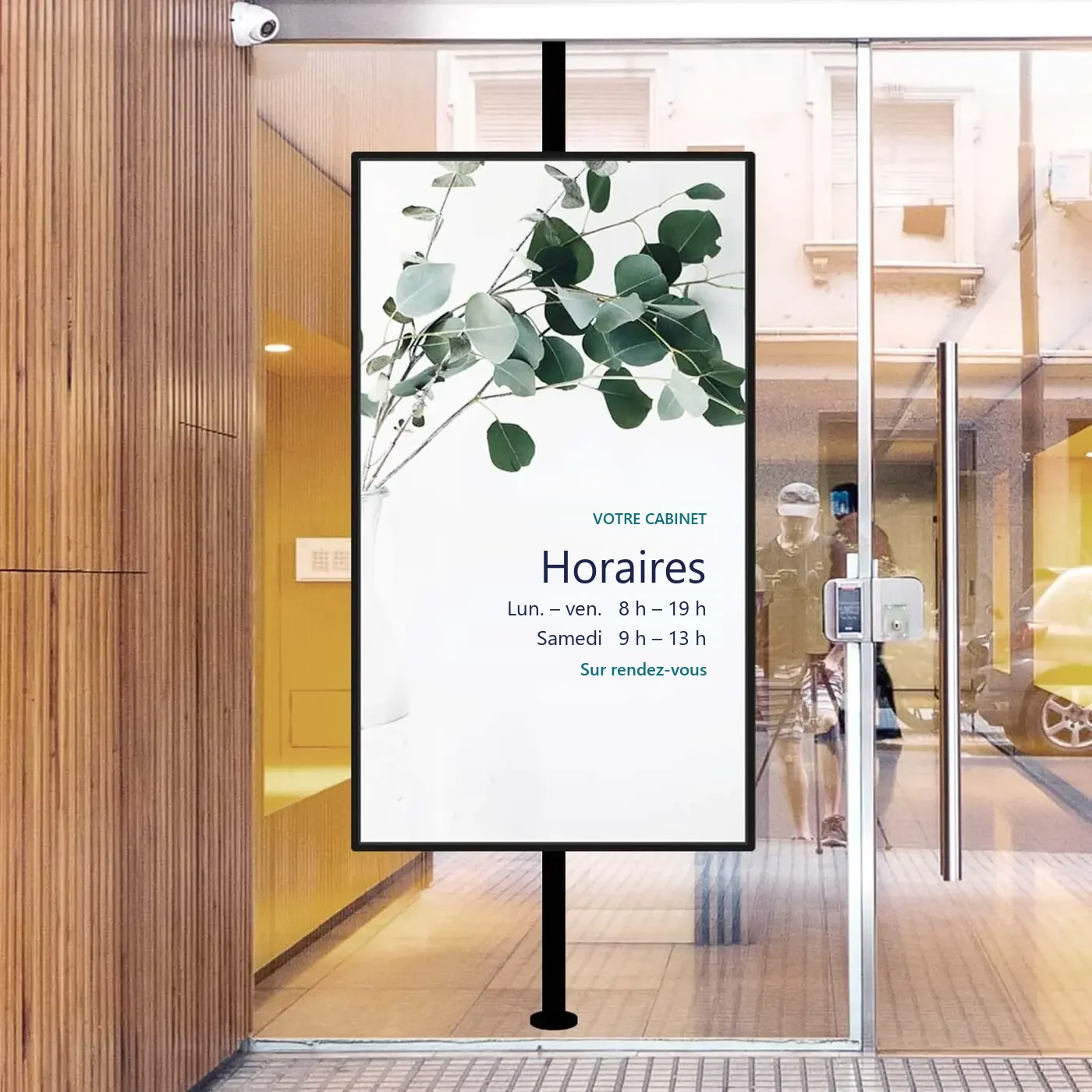 Écran vertical dans une entrée, affichant les horaires