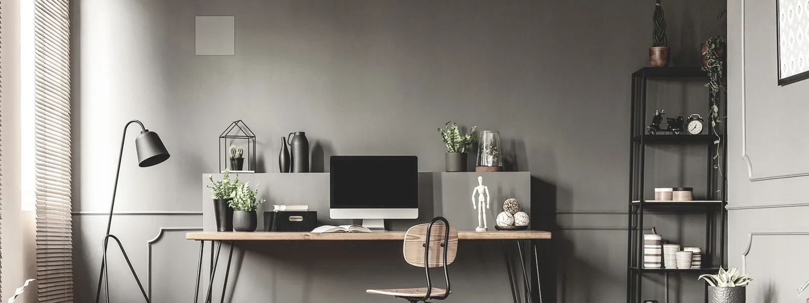 Enceinte carrée ArtSound FLAT encastrée dans le mur, au-dessus d’un bureau design gris