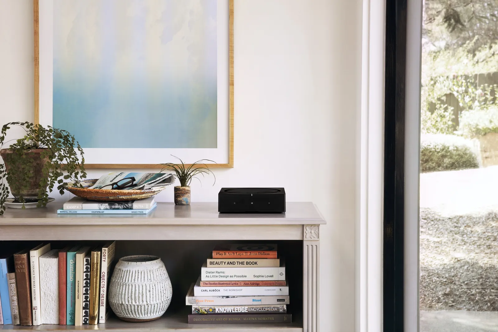 Amplificateur Sonos Amp posé dans une bibliothèque, dans un intérieur soigné