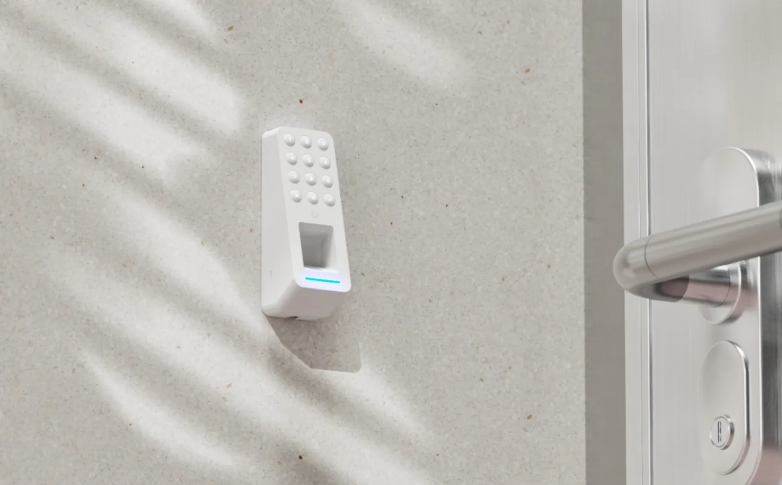 Witte UniFi Access G3 Reader Fingerprint-lezer op een lichte muur naast een deurklink